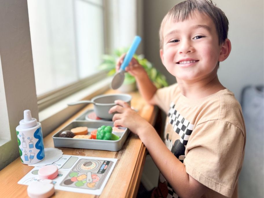 Little boy playing with Melissa & Doug Water WOW Saute & Serve Play Set