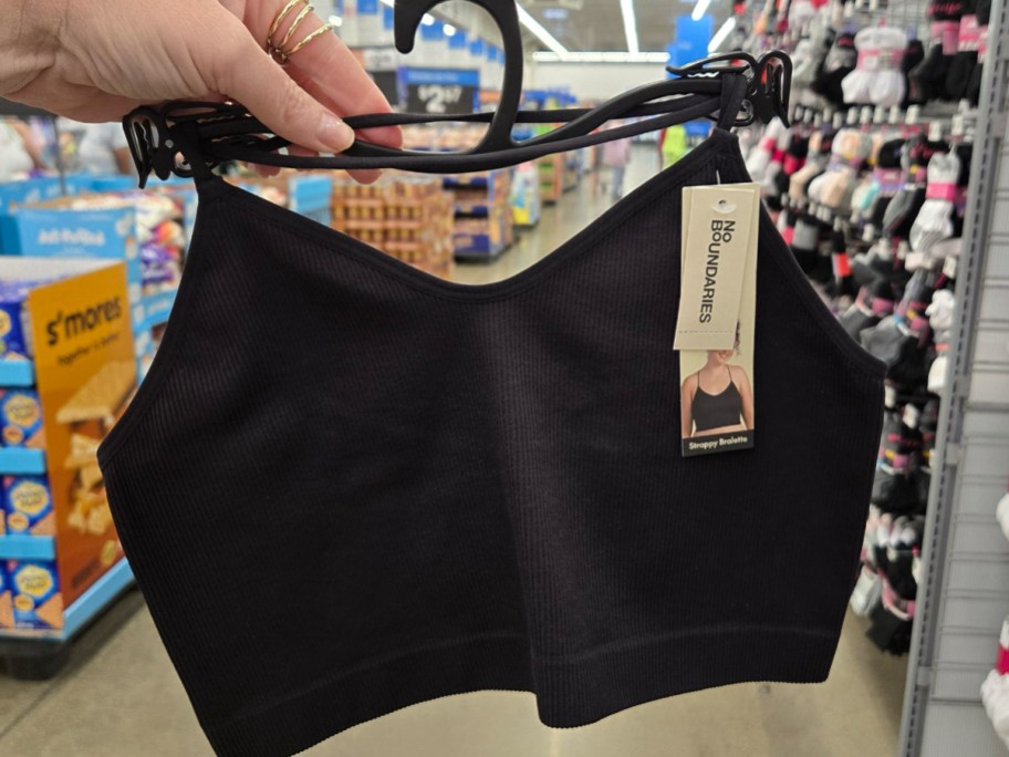 No Boundaries Strappy Back Cami in black being held in a walmart aisle