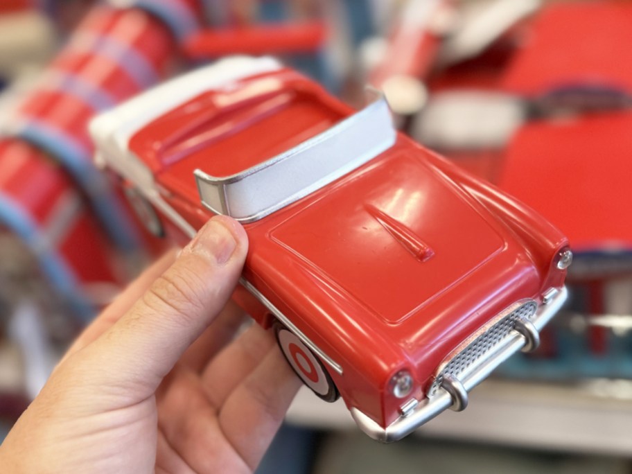 hand holding a retro red car figurine