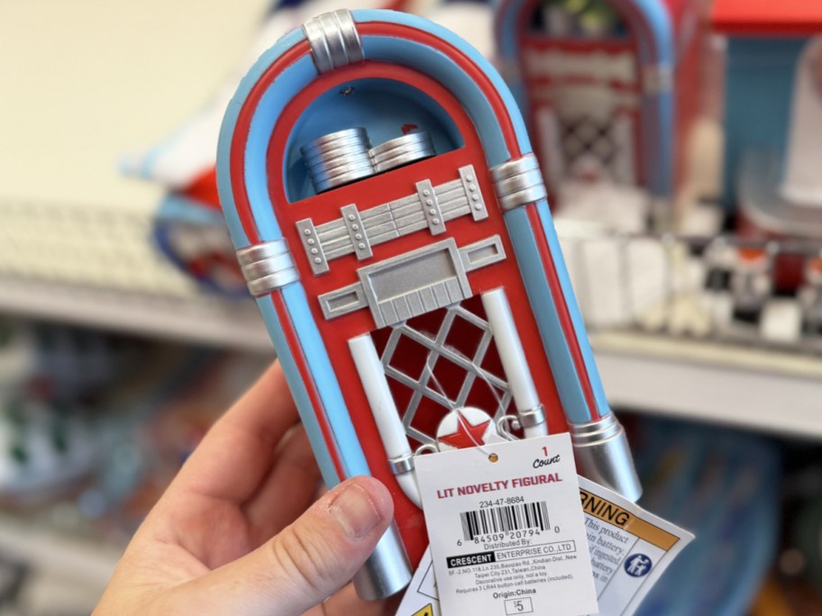 hand holding a red and blue jukebox figurine
