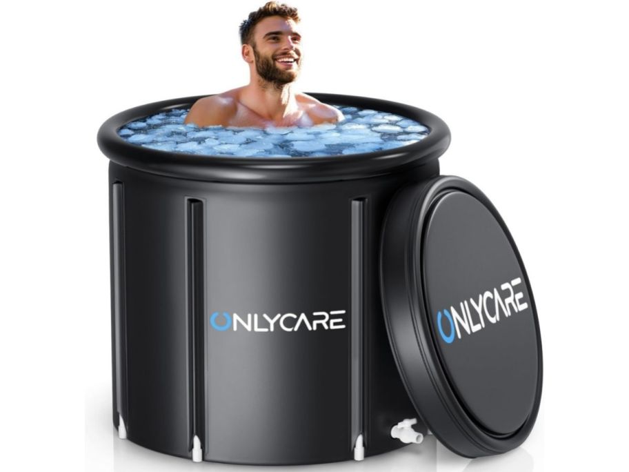  Man inside of ice bath black tub with lid to the side