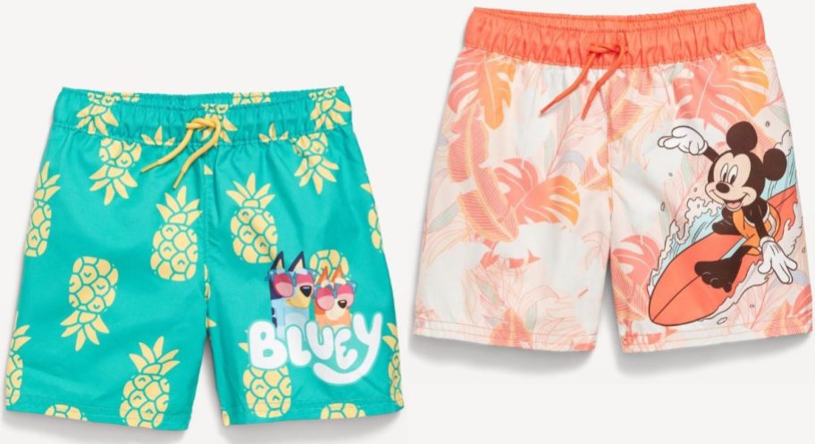 Stock images of two Old Navy Toddler Boy's Licensed Graphic Swim Trunks featuring Bluey and Mickey Mouse