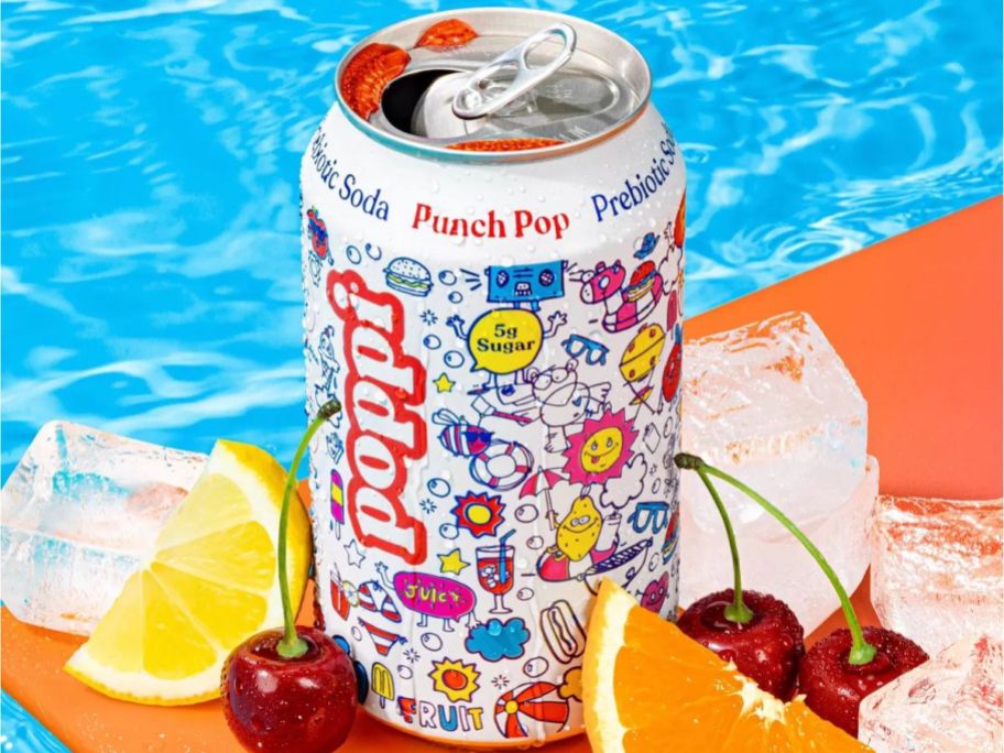 An open can of Poppi Punch Pop surrounded by cherries, lemons, orange slices, and ice