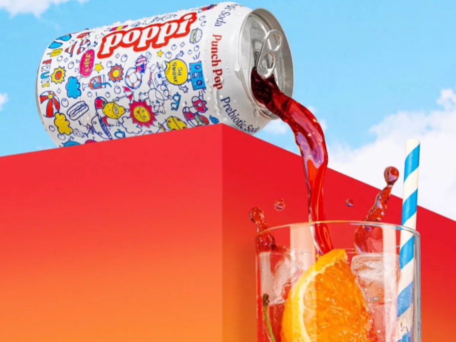 a can of poppi punch pop being poured into a glass of ice with an orange in it