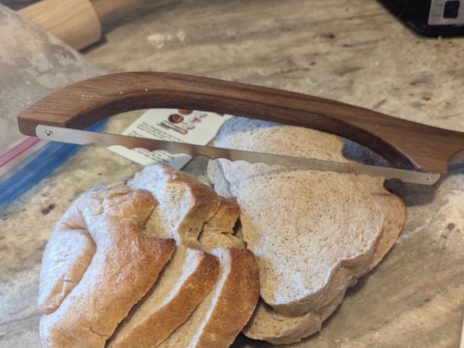 A bread knife on a cutting board with bread