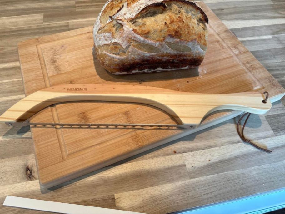 A bread knife on a cutting board with bread