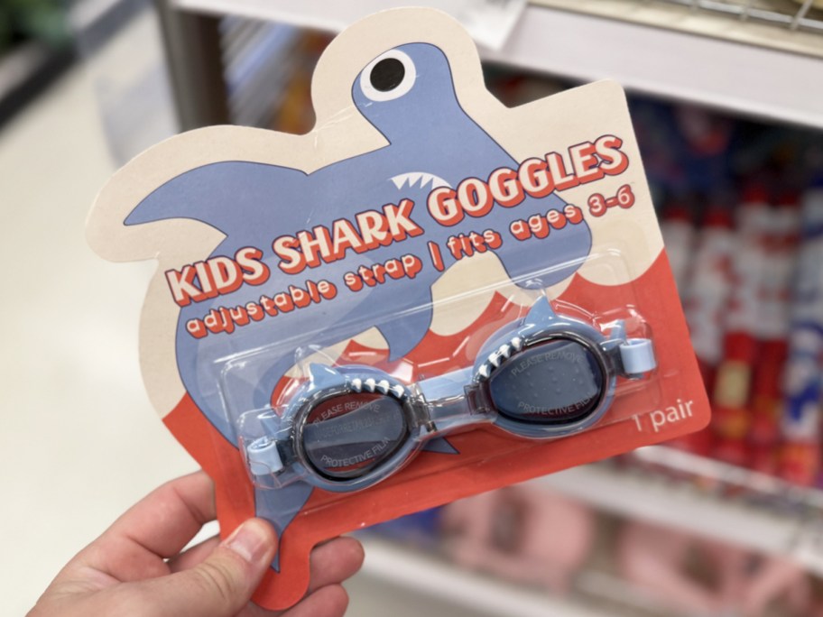 hand holding a set of shark goggles in store