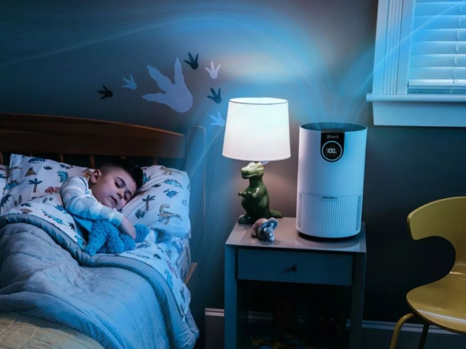 child sleeping in a room with a shark air purifer on his nightstand