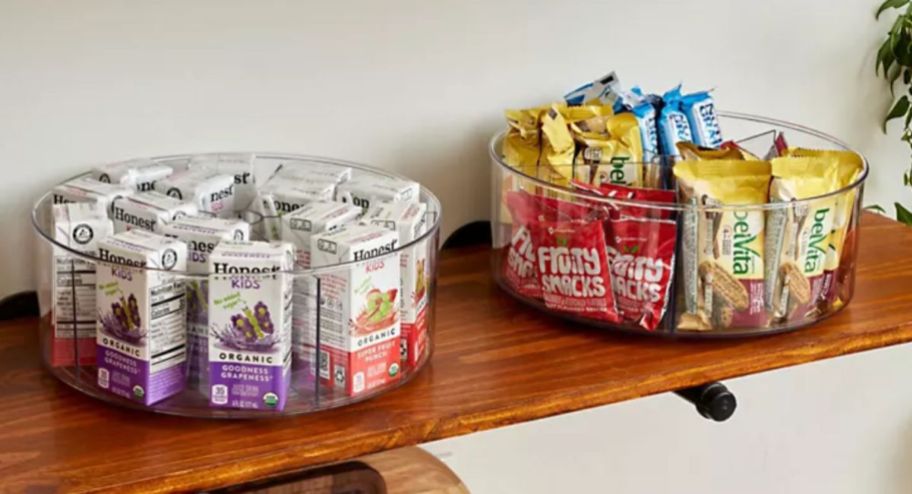 Two clear lazy susans displayed with snacks inside 