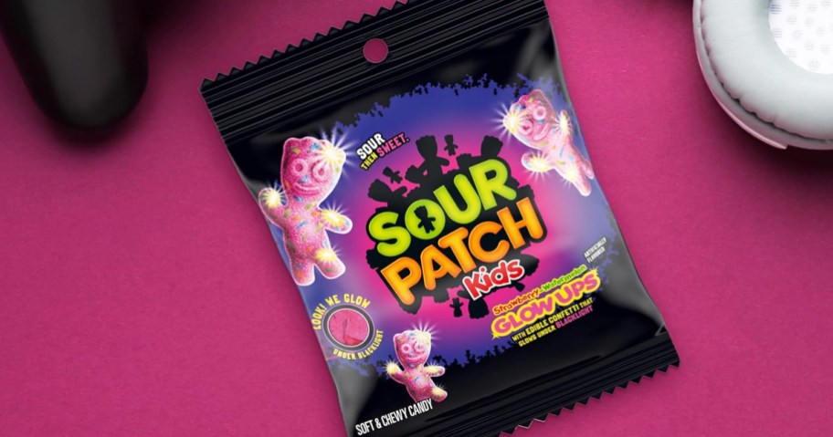 bag of Sour Patch Kids Glow Ups candy on a pink background