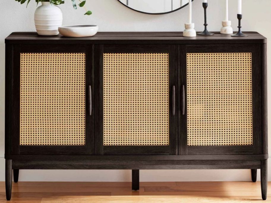 a dark wood and caning styled sideboard with 3 doors