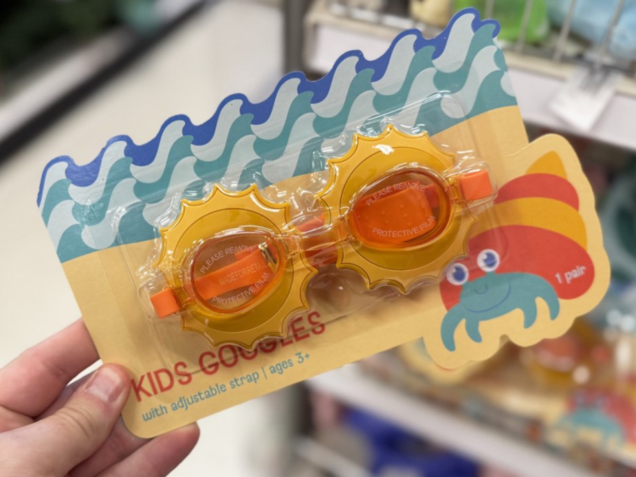 hand holding a pair of sun shaped goggles in store