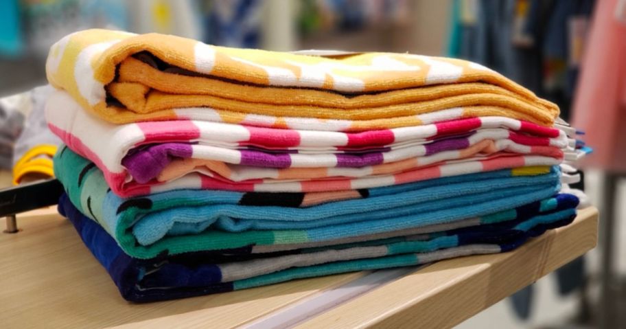 beach towels folded and stacked on a shelf at target