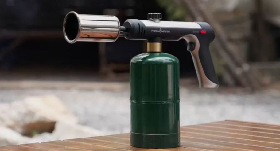 propane torch on a wooden table outside