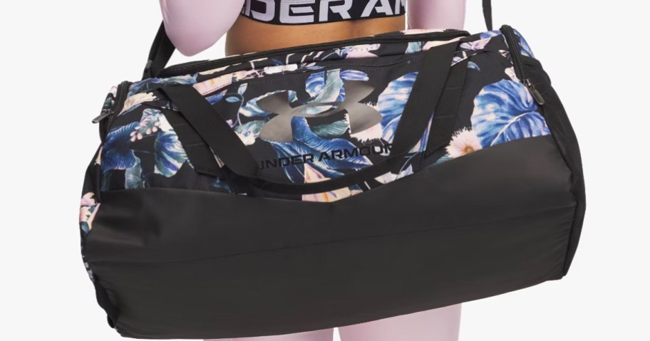 woman with a black and blue floral print under armour duffle bag