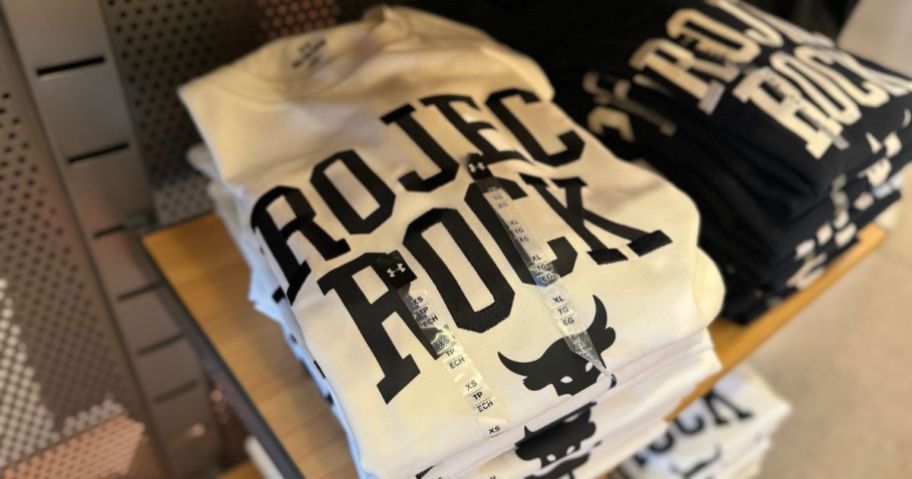 A folded stack of Under Armour Project Rock T-Shirts