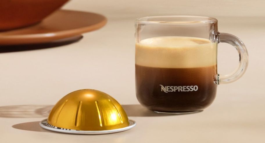 voltesso coffee pod next to a coffee cup on top of a table