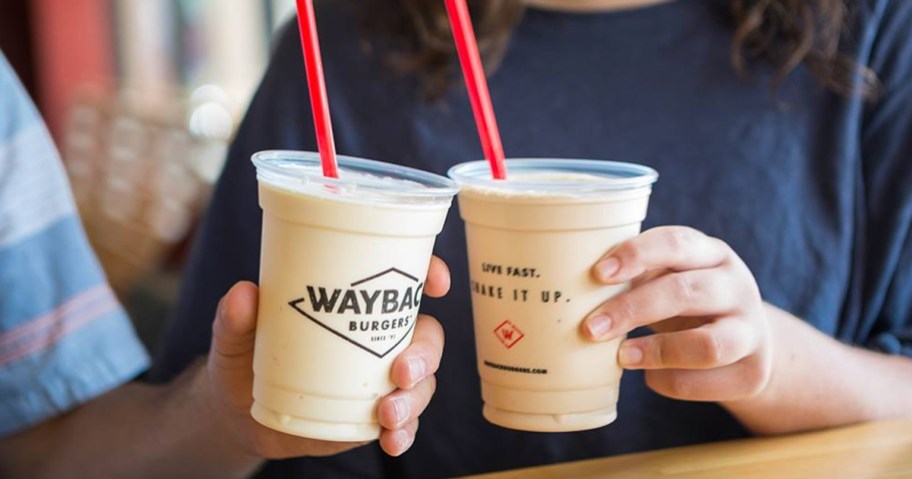 two people holding up milkshakes from Wayback Burgers