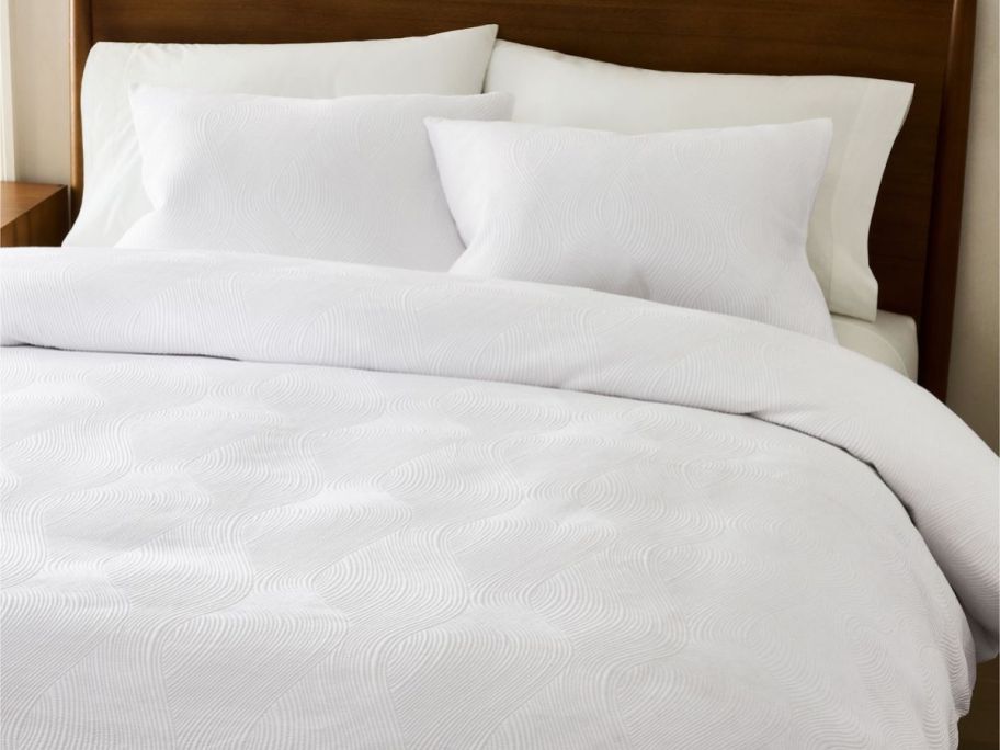 A White West Elm Comforter on a bed with shams