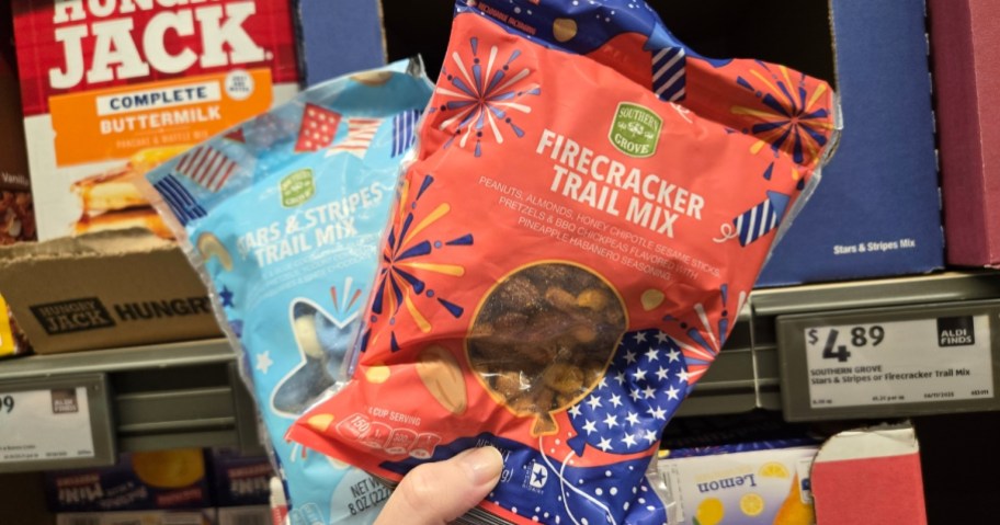 hand holding 2 bags of red, white, and blue, patriotic themed trail mix