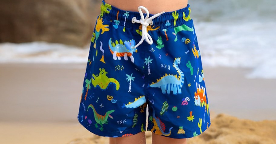 boy wearing swim trunks at the beach
