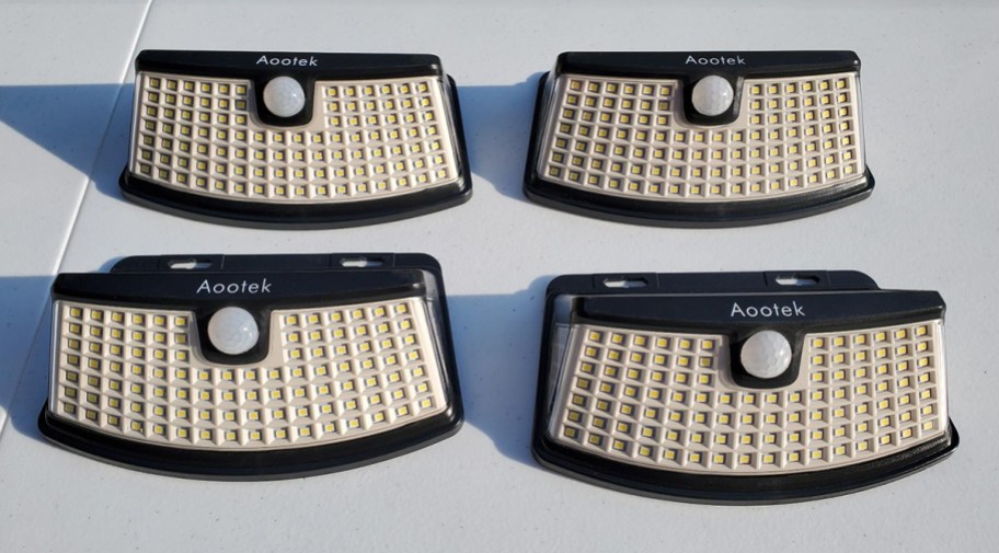 four solar lights sitting on a table during the day