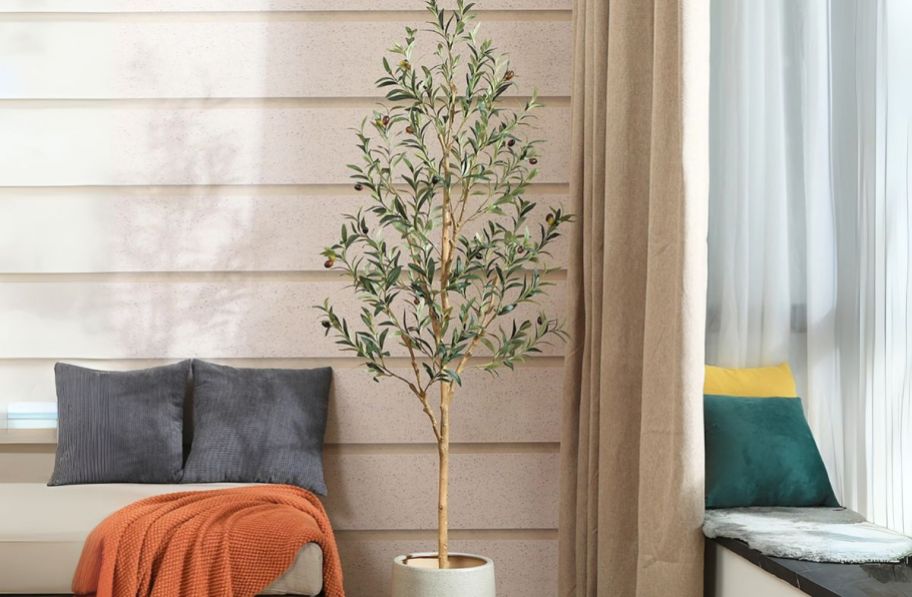 artificial olive tree next to a chaise lounge