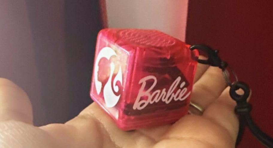 hand holding mini barbie speakers