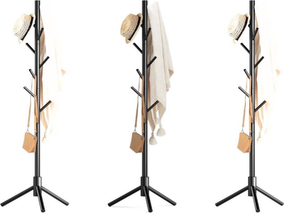 three coat racks with hat, purse, and sweater hanging on them