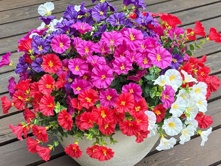 red, pink, purple, and white flowers in pot on deck