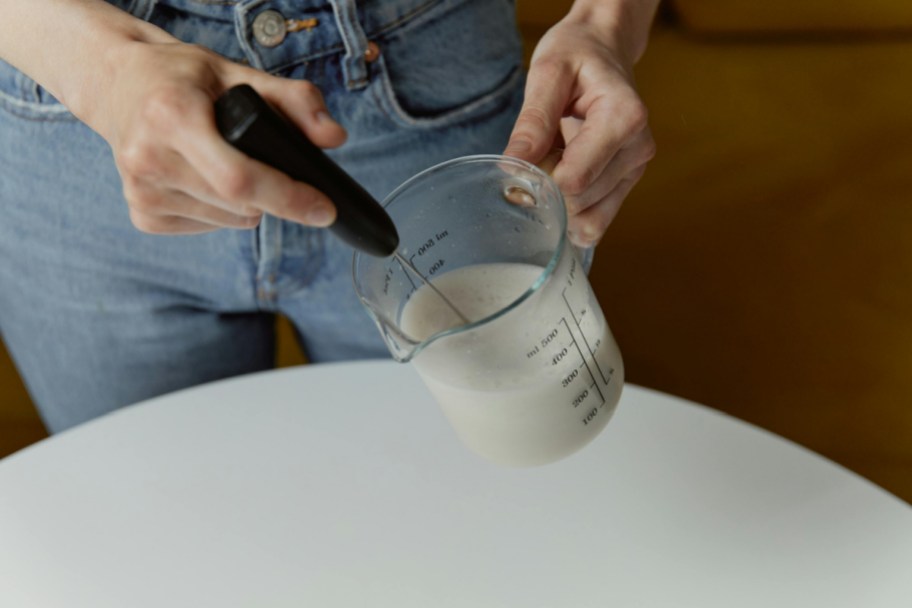handheld frother in glass of milk or cream