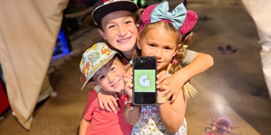 kids holding up phone with getout pass on it 