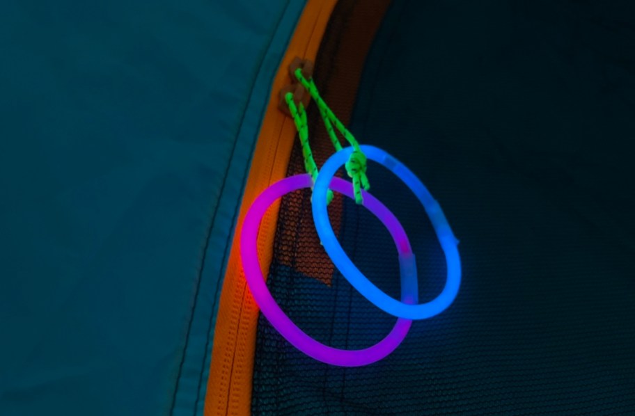 pink and blue glow sticks on tent zippers