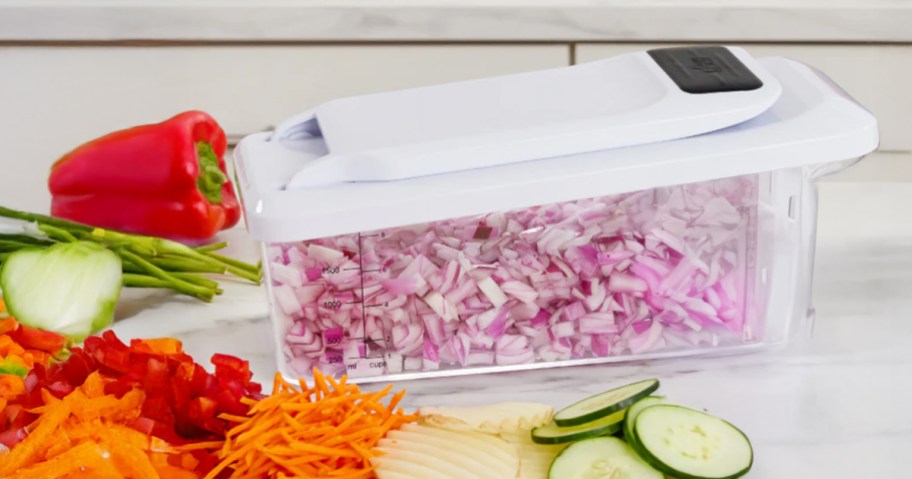 gorilla grip veggie chopper sitting on a counter with various vegetables surrounding it