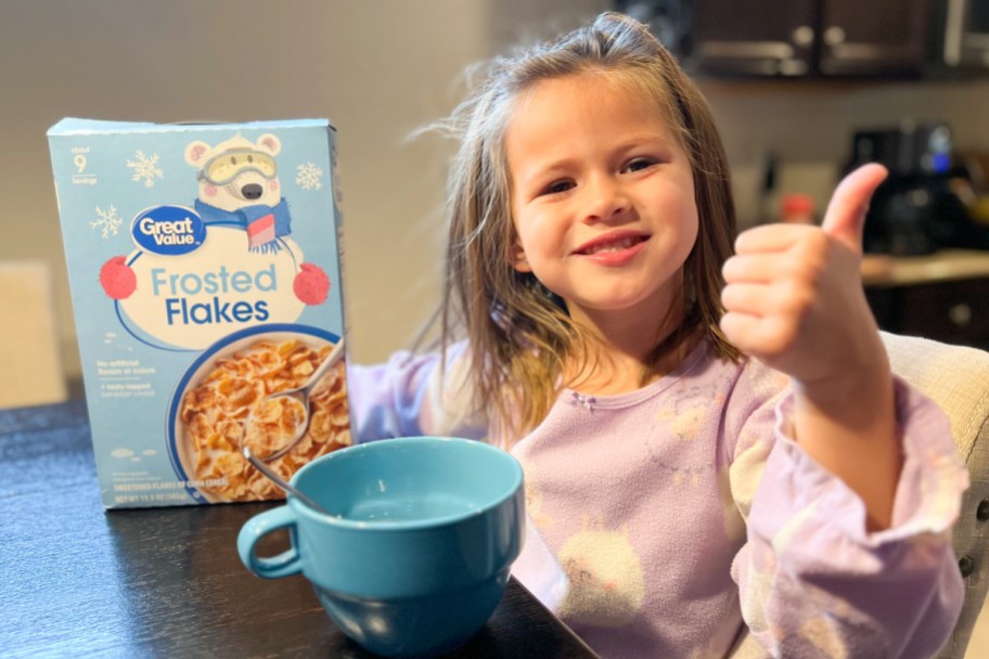 girl eating frosted flakes cereal with thumbs up