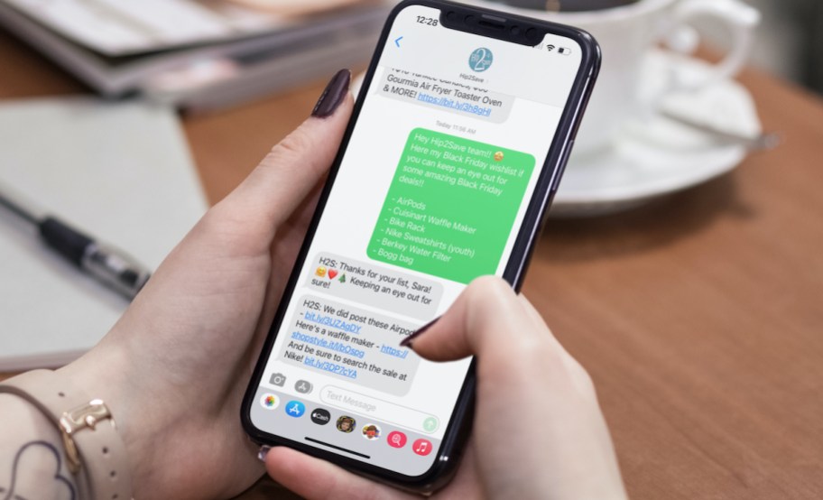hand holding phone with texting black friday deals and wishlist