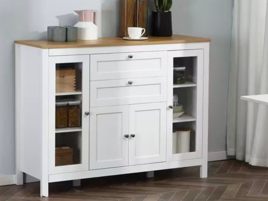 white buffet table with kitchenware on top 