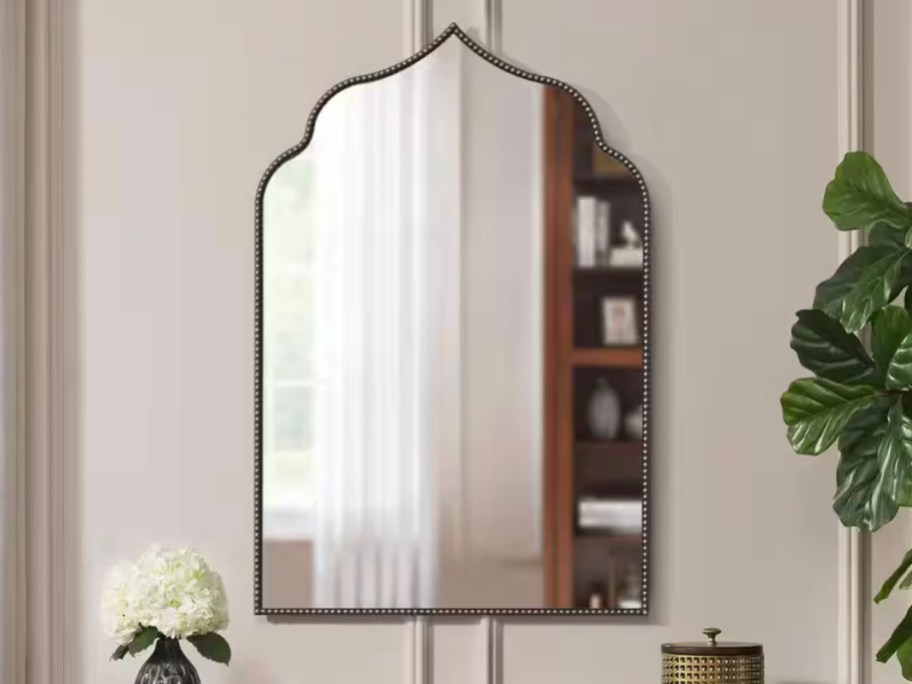 gold framed arch mirror hanging on wall 