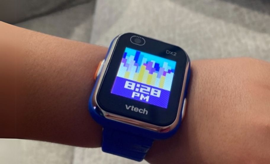 a kiddos wrist with a smartwatch on it. 