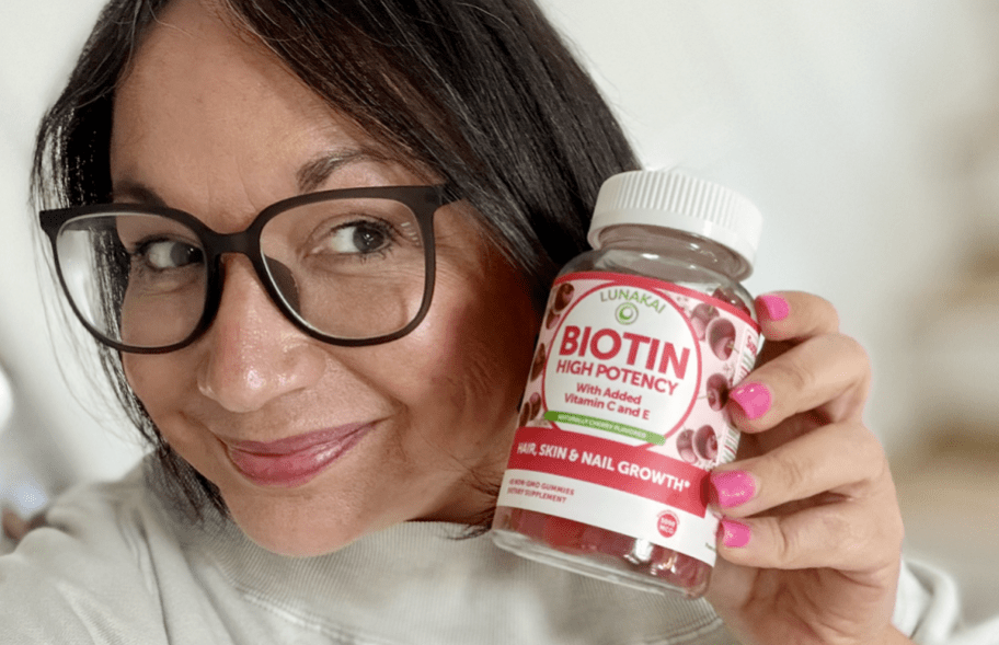 woman holding bottle of biotin gummies