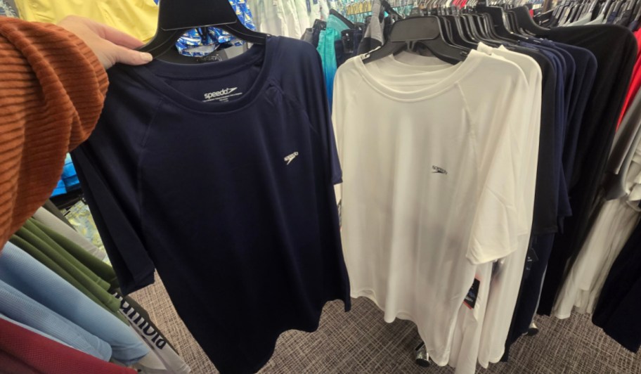 navy and white rash guards on hangers in store