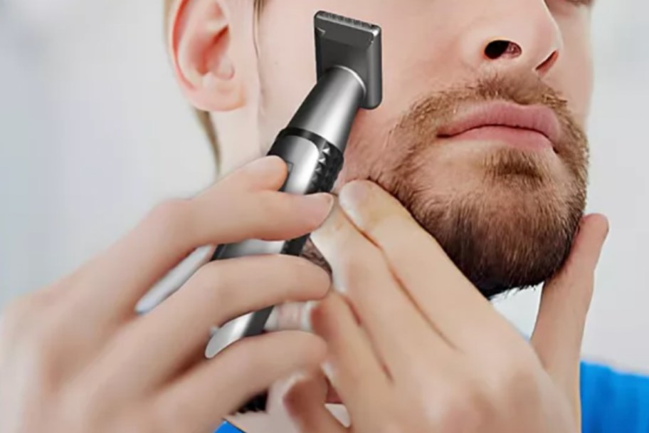 man holding trimmer up to face