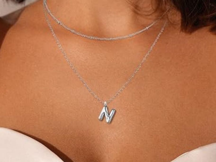 woman wearing initial necklace