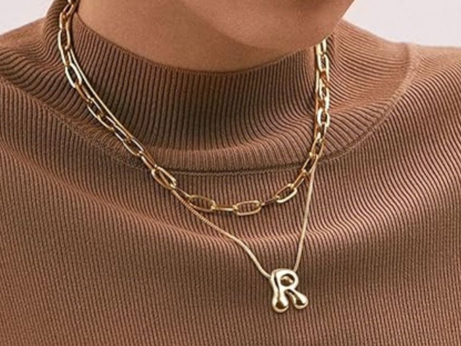 woman wearing initial necklace