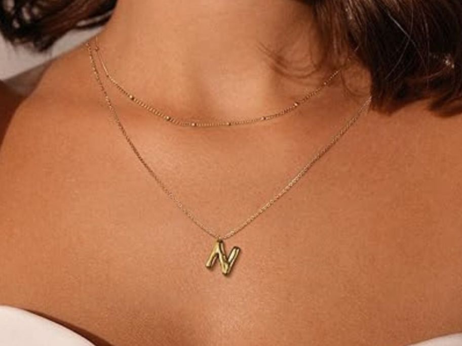 woman wearing initial necklace
