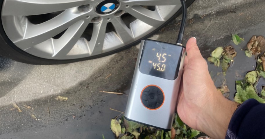 person using tire compressor on bmw tire