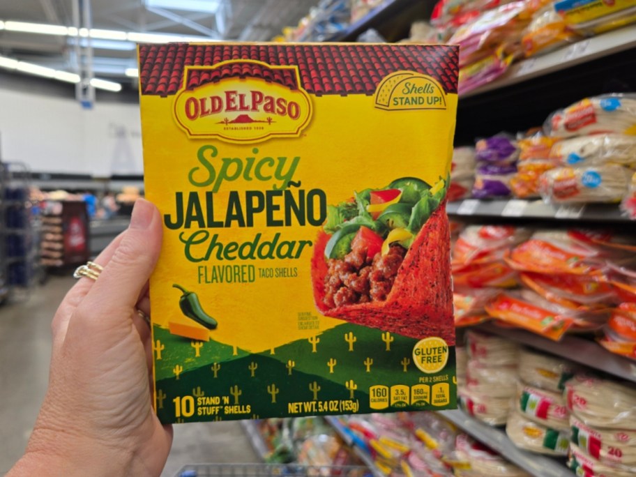hand holding a box of Old El Paso Spicy Jalapeño Cheddar Flavored Stand 'N Stuff Taco Shells