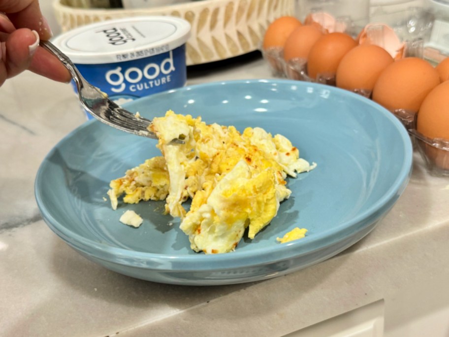 plating scrambled cottage cheese eggs onto a plate