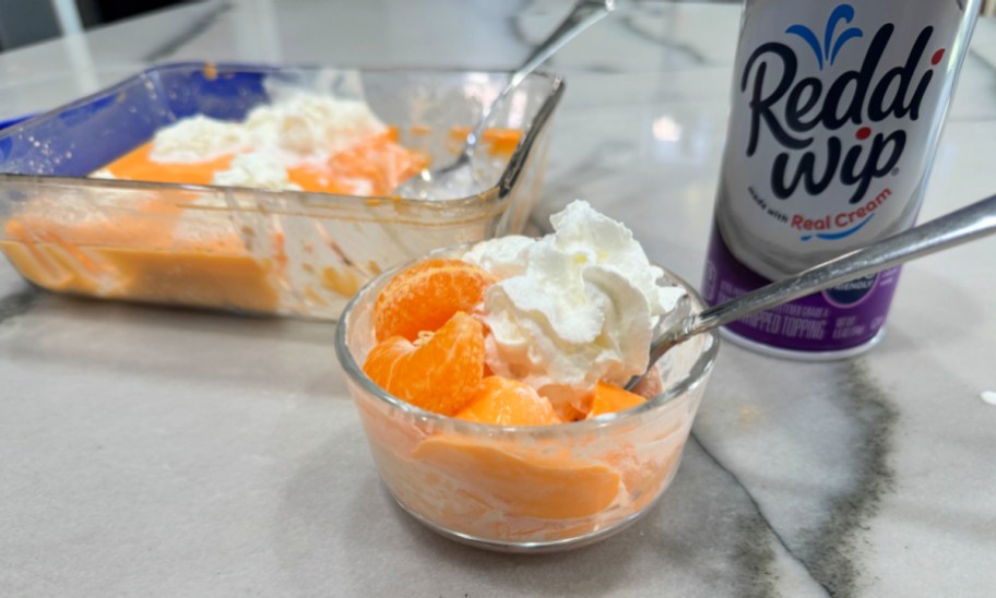 serving of orange protein jell-o with oranges and whipped cream