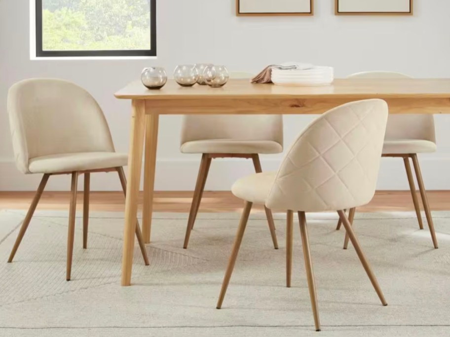 upholstered beige and wood dining chairs next to table